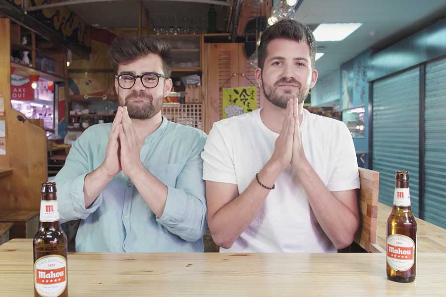 Imagen de Kikillo y el instagramer Kino Jerez sentados juntos en un bar de sushi, mirando a la cámara. Campaña de Branded Content Mahoudrid para Mahou.