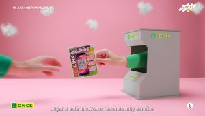 Fotograma del video: Una mano pasando un boleto de lotería a otra mano, ambas vestidas con suéteres verdes en el videotutorial producido por Colirio Films, productora audiovisual Madrid